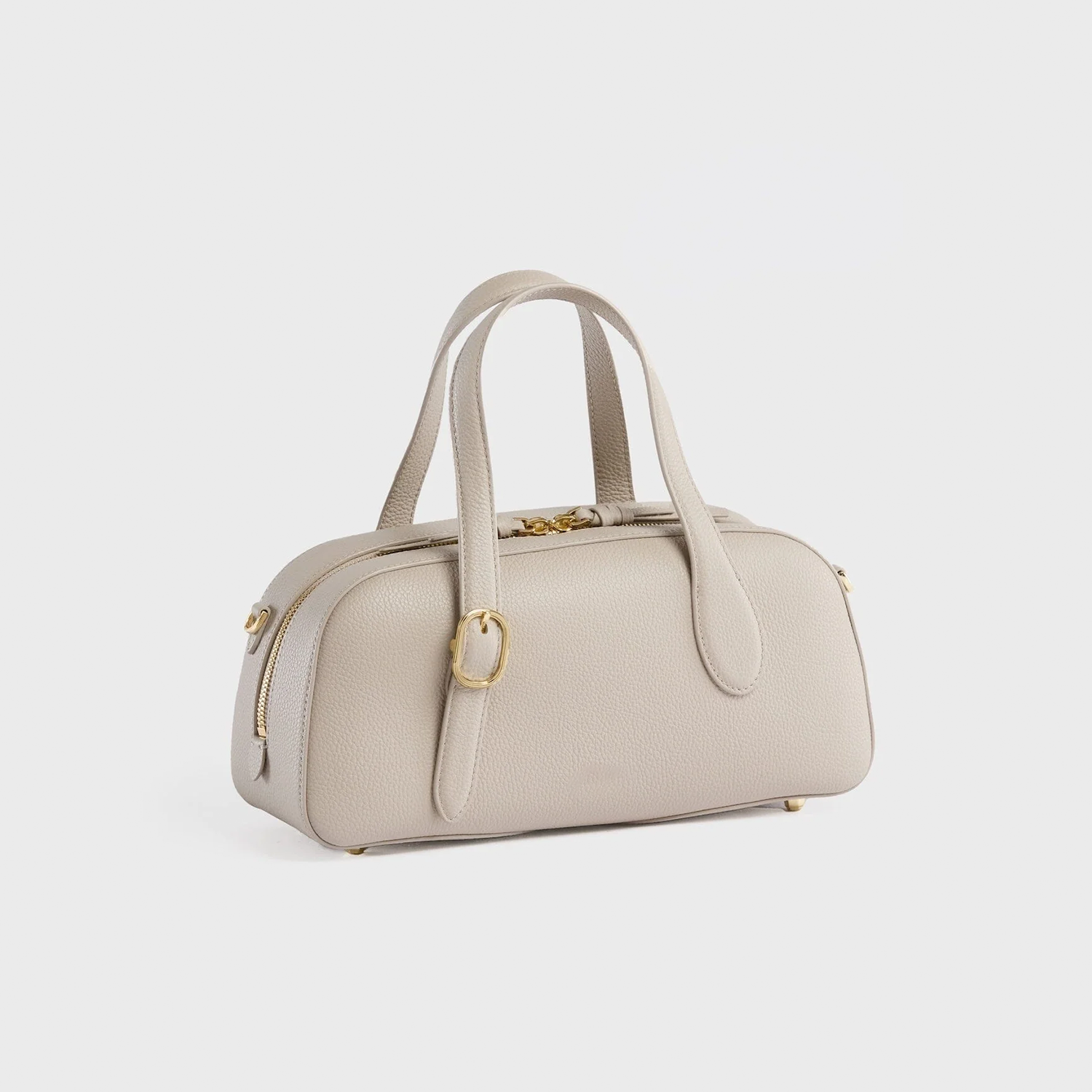 Calm Pale Ash Grey Compact Oval Barrel Carryall With Polished Golden Zipper Hardware And Base Protective Metal Studs